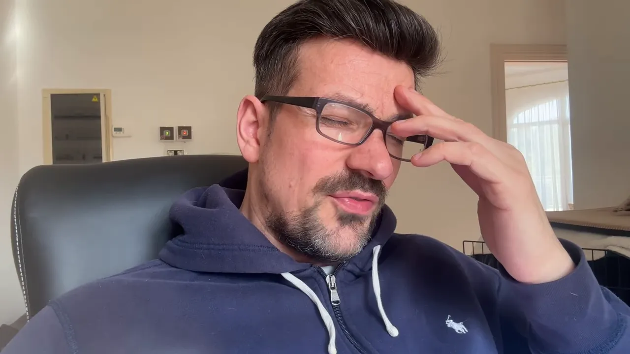 Mann hält sich die Hand an die Stirn und schließt die Augen, nachdenklich