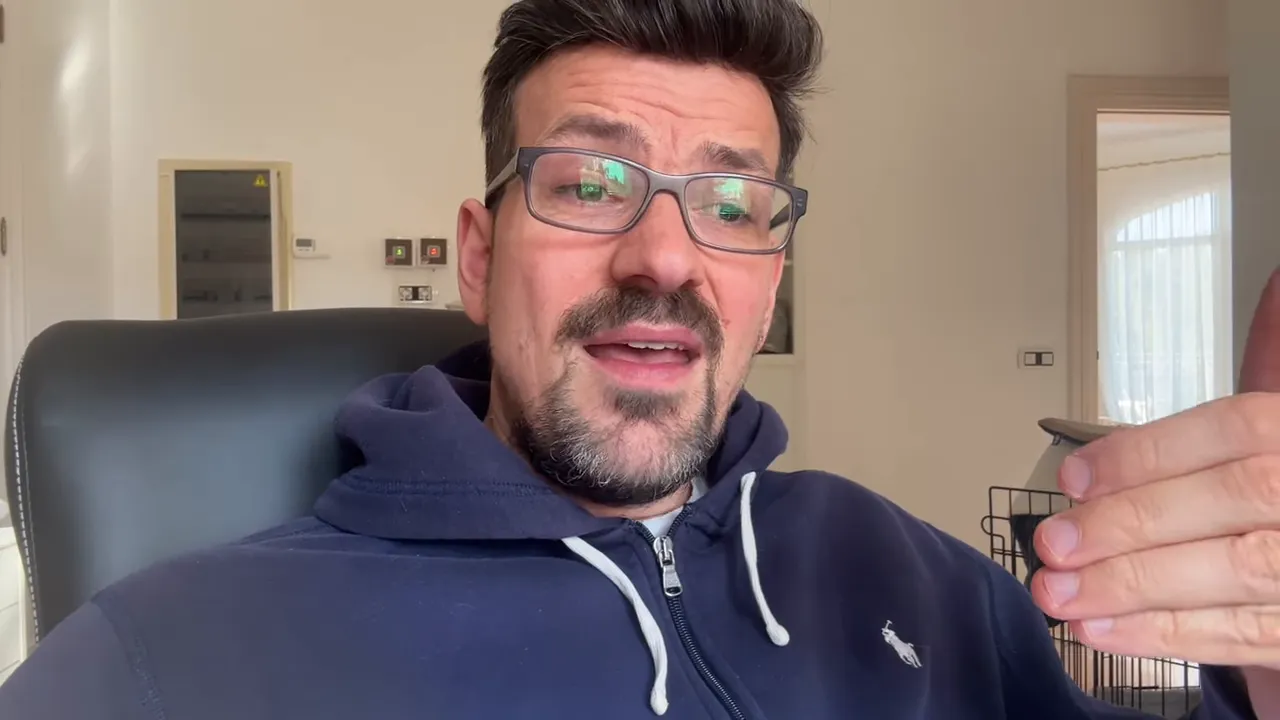 Mann spricht in Videoaufnahme mit erklärender Handgeste, angenehme Bildkomposition, Bürohintergrund