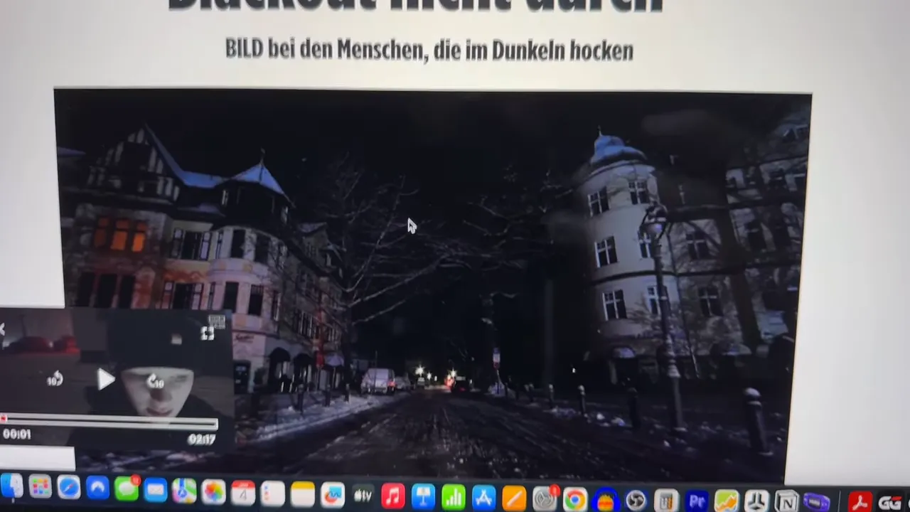 Nachtaufnahme einer schneebedeckten Berliner Wohnstraße mit kaum beleuchteten Häusern und wenigen Lichtquellen.