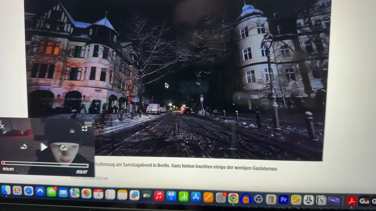 Verschneite Straße in Berlin bei Nacht mit Fußspuren im Schnee und Straßenlaternen