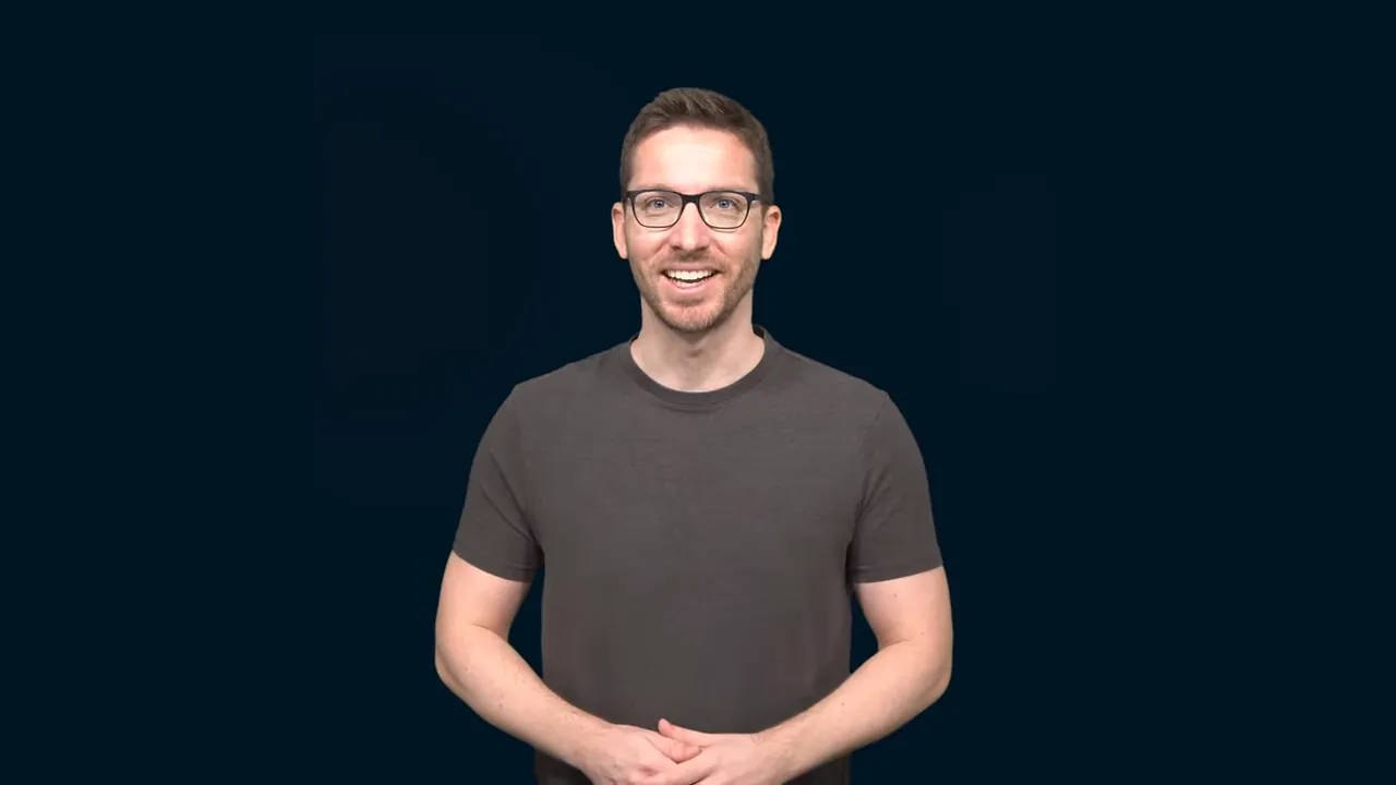 Lächelnde Person steht vor dunklem Hintergrund und spricht in die Kamera, klare und freundliche Aufnahme