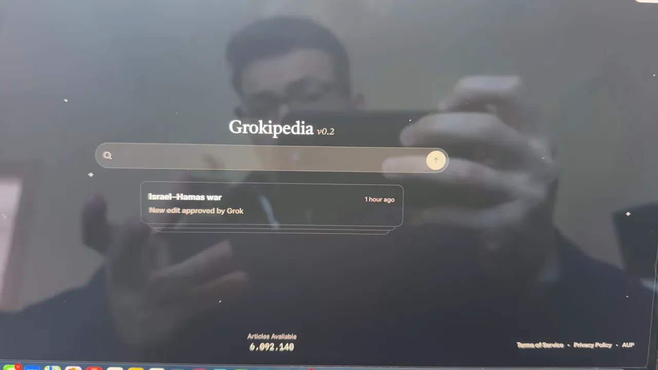 Screenshot der Grokipedia-Startseite mit Suchleiste und einem sichtbaren Ergebnis zum 'Israel–Hamas war'; leichte Bildschirmreflexion.