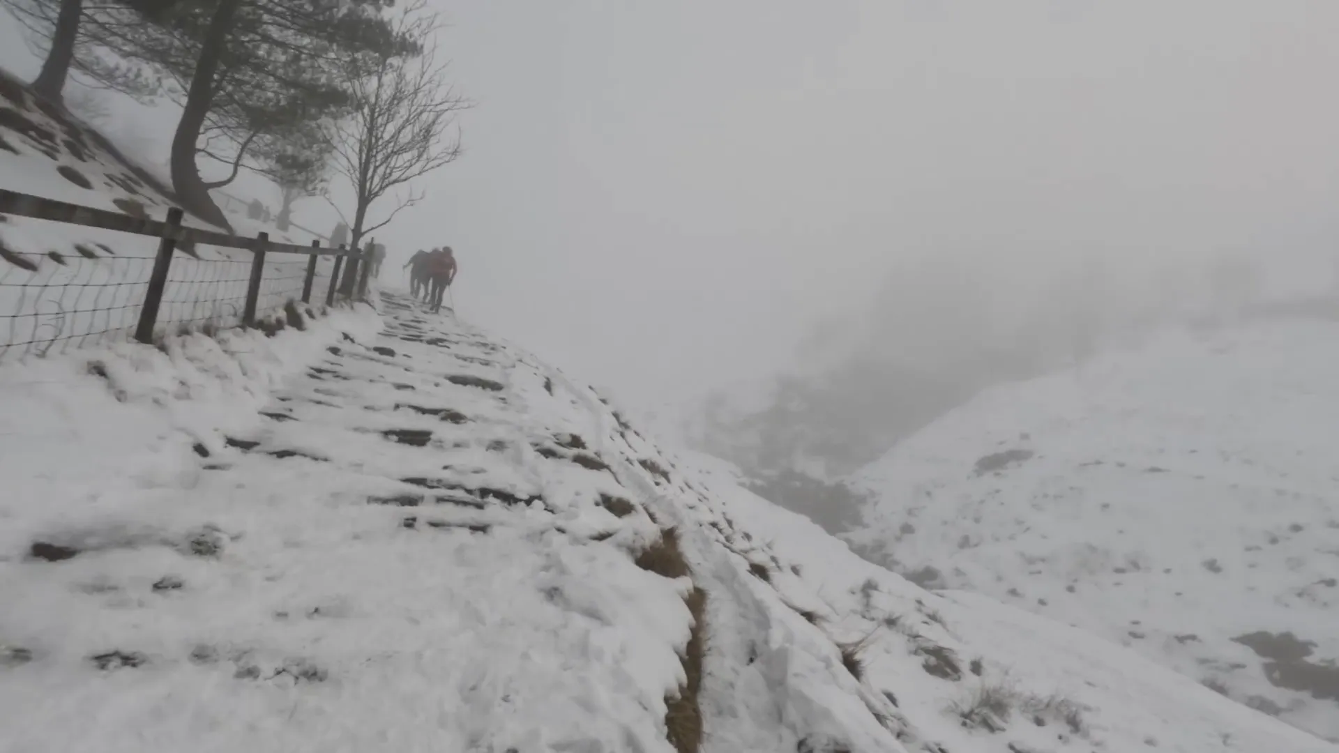 Climbing Jacob's Ladder with snow-covered terrain and valley clouds below