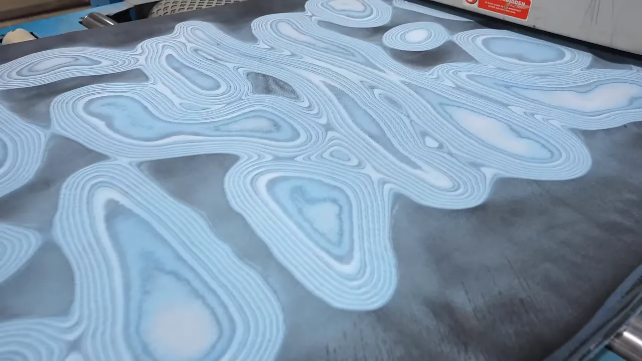 Surfaced denim slab showing light and dark concentric patterns beside the planer