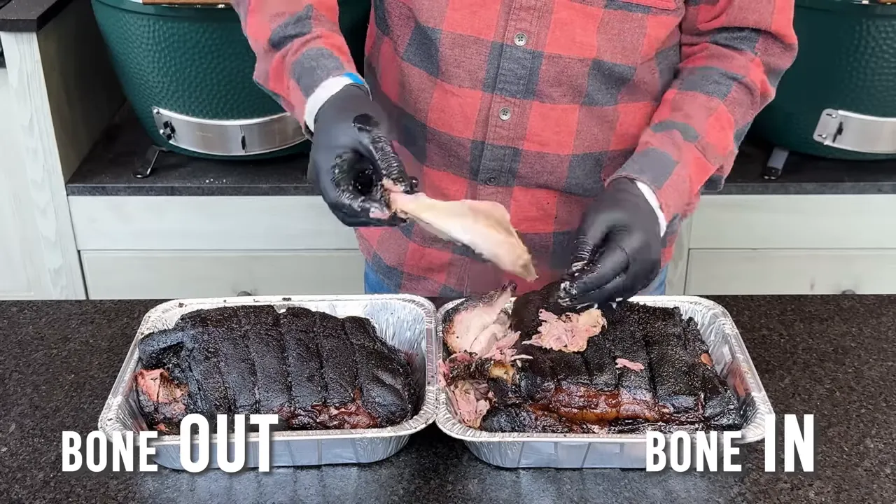Gloved hands pulling a bone from a pork shoulder beside a second roast in an aluminum pan