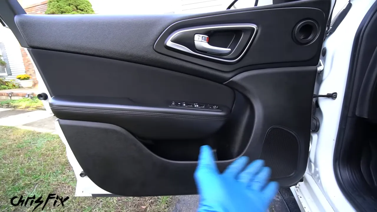 Clean black driver door panel with silver handle and empty storage pockets