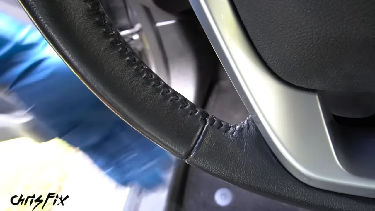 Close-up of clean black steering wheel material and stitching
