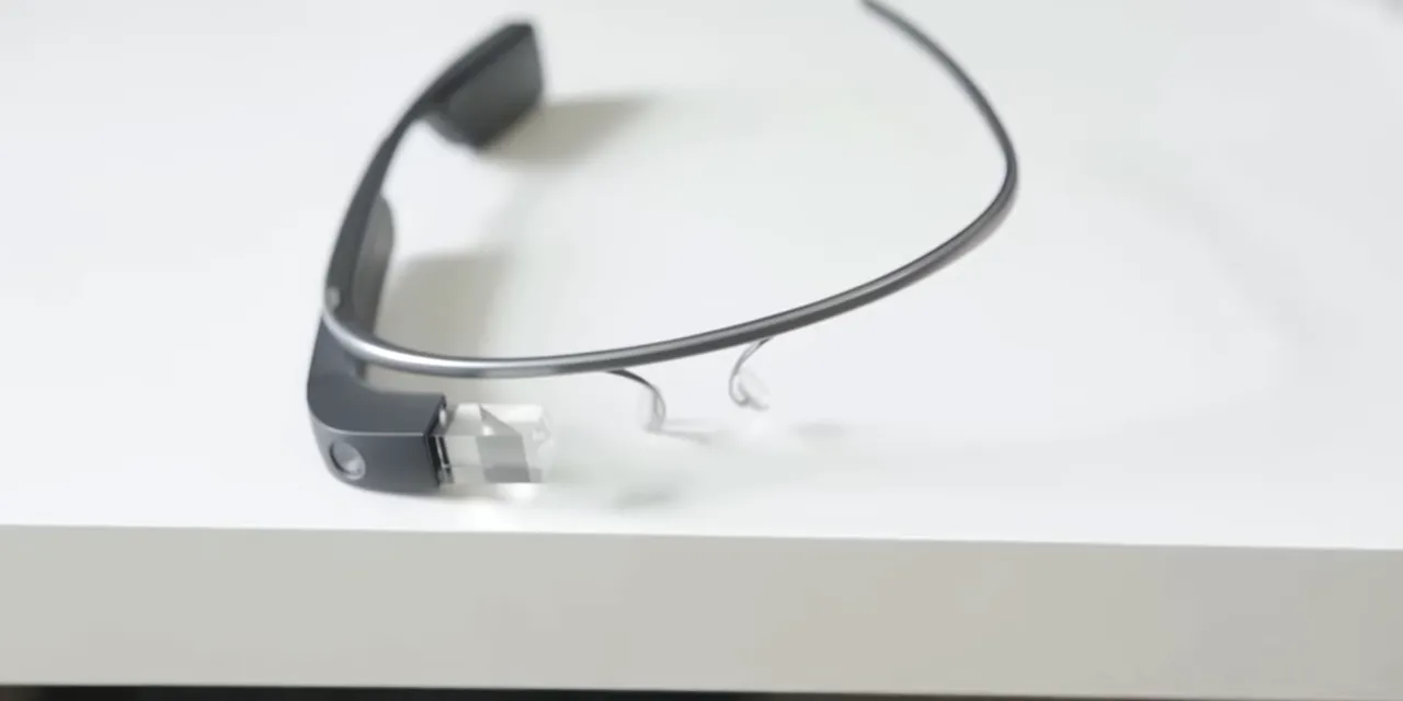 Google Glass resting on a white tabletop with its frame and display module visible