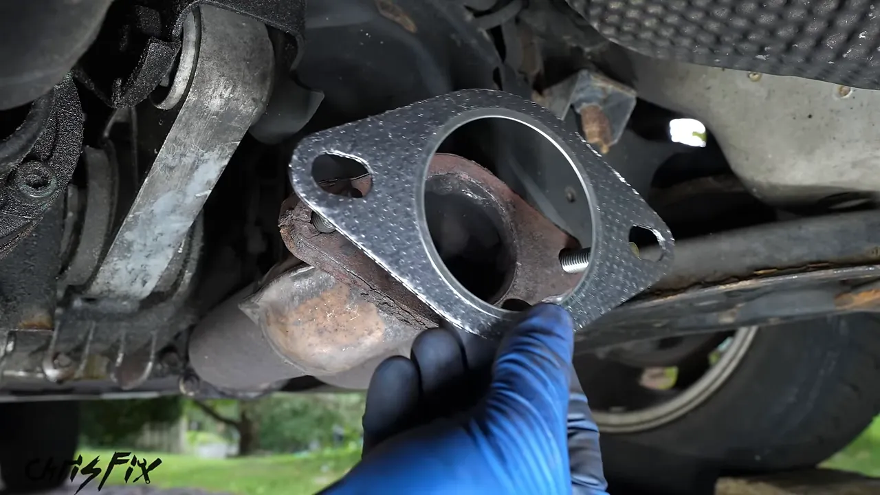New exhaust gasket positioned on bolts at the cleaned front flange