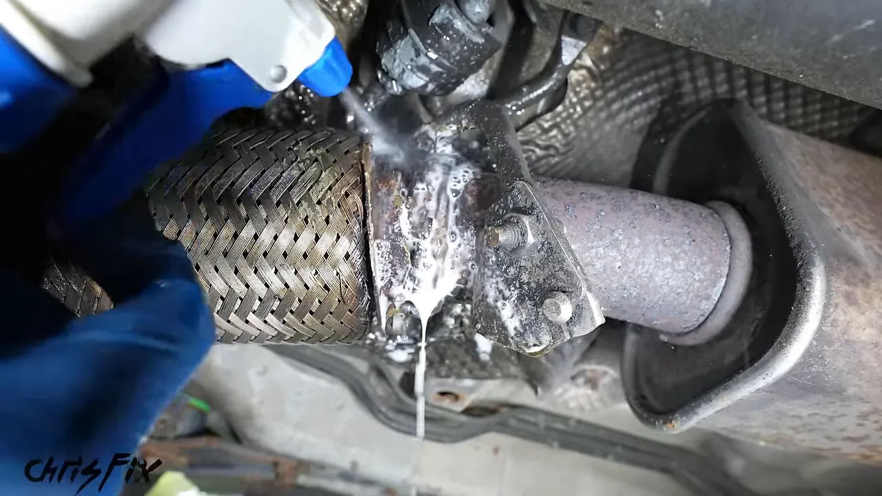 Soapy bubbles around the rusty connection beside a braided exhaust flex pipe