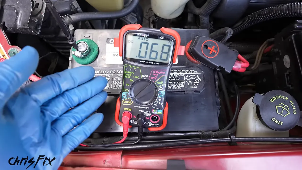 Multimeter connected at the battery displaying approximately 0.070 amps