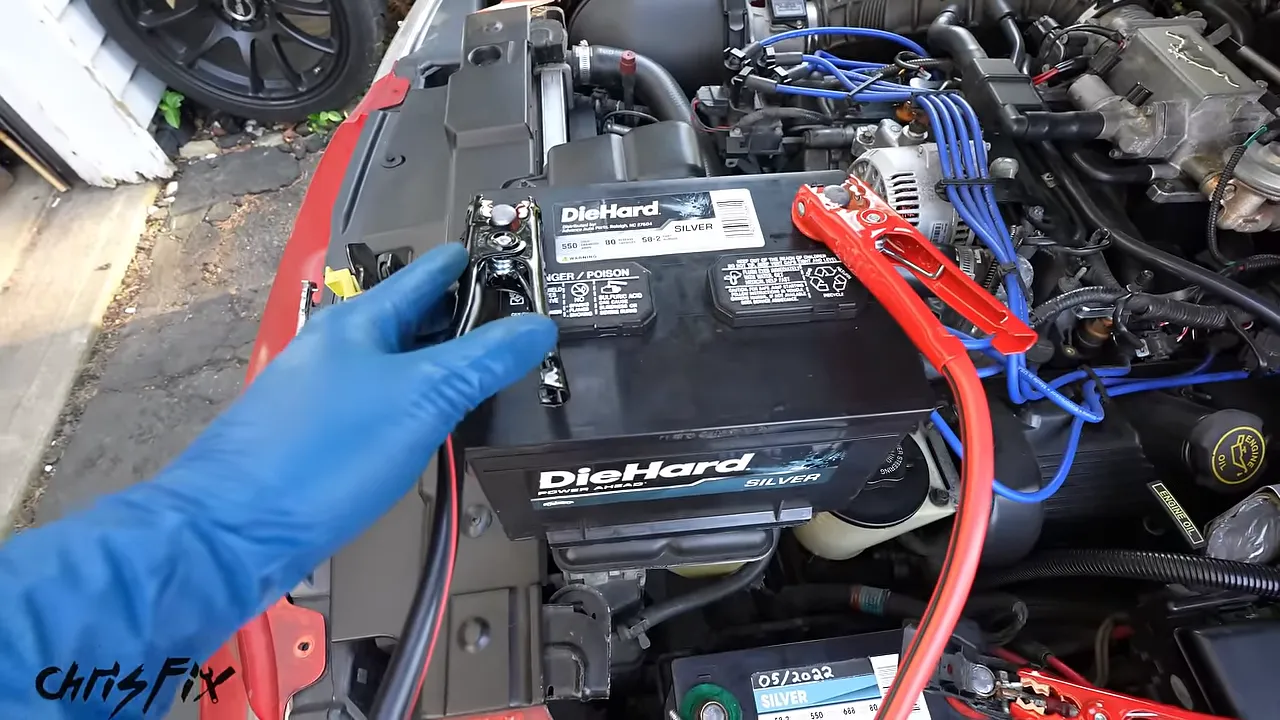 Replacement battery beside the engine bay connected with red and black jumper cables