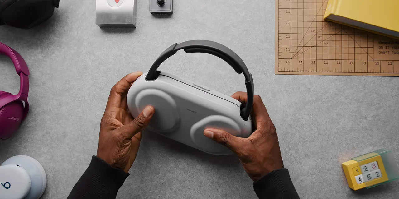 Nothing headphones inside a white hard-shell case with the headband exposed above it