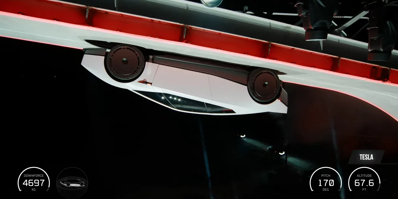 White Roadster hanging upside down beneath the curved demonstration ramp
