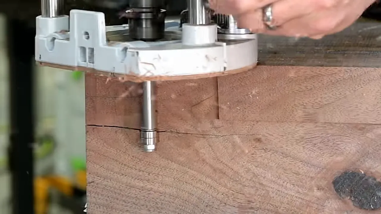 Flush-trim router bit cutting along the side of the thick walnut beam