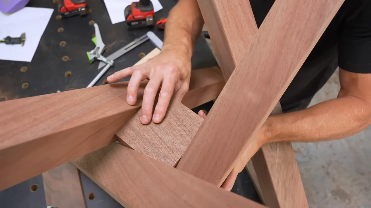 Walnut center block fitted between the crossing legs of the unfinished spider base