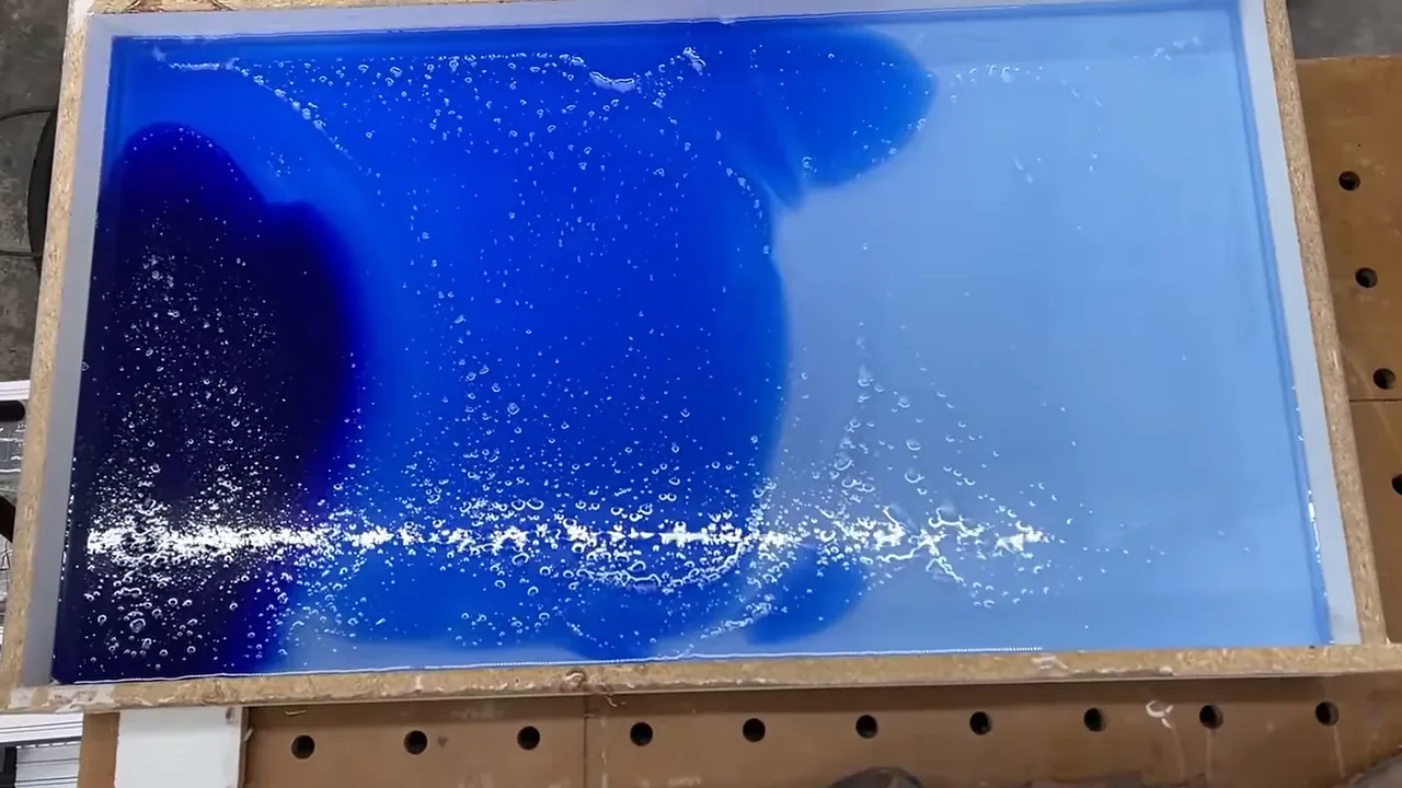Rectangular mold filled with epoxy transitioning from deep blue to pale blue