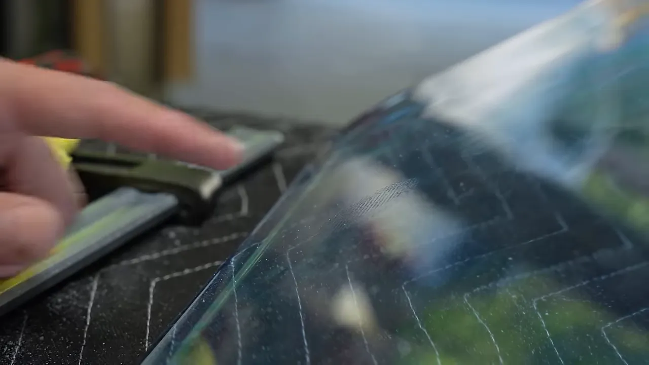 Finger pointing to a textured impression on the glossy blue epoxy surface