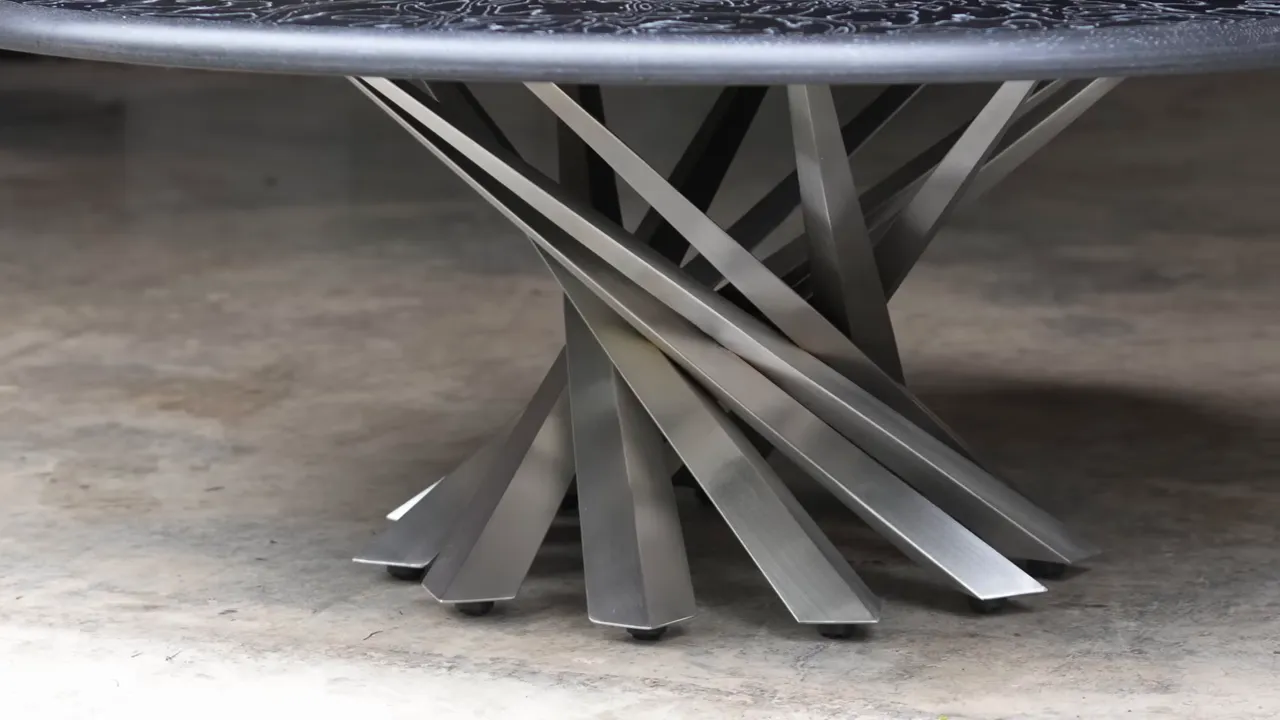 Round patterned coffee table shown with black and silver sculptural metal bases