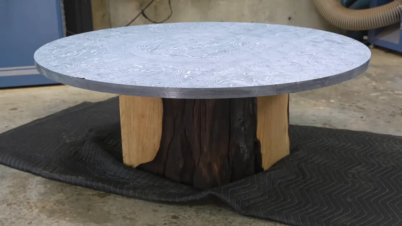 Circular pale patterned tabletop resting on a chunky oak block with charred sides