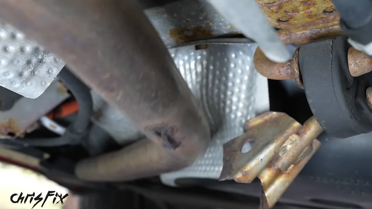 Broken rusted exhaust bracket beside the Prius exhaust pipe