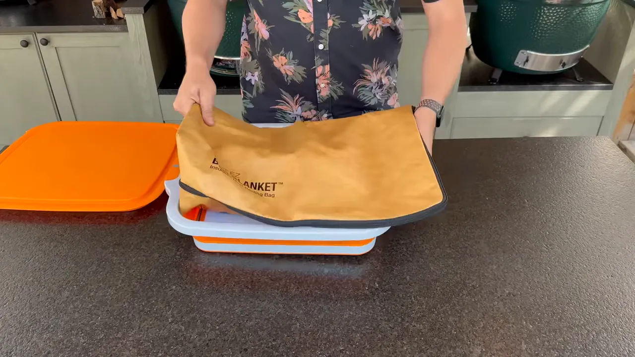 A tan insulated resting blanket being placed inside an orange and white prep tub
