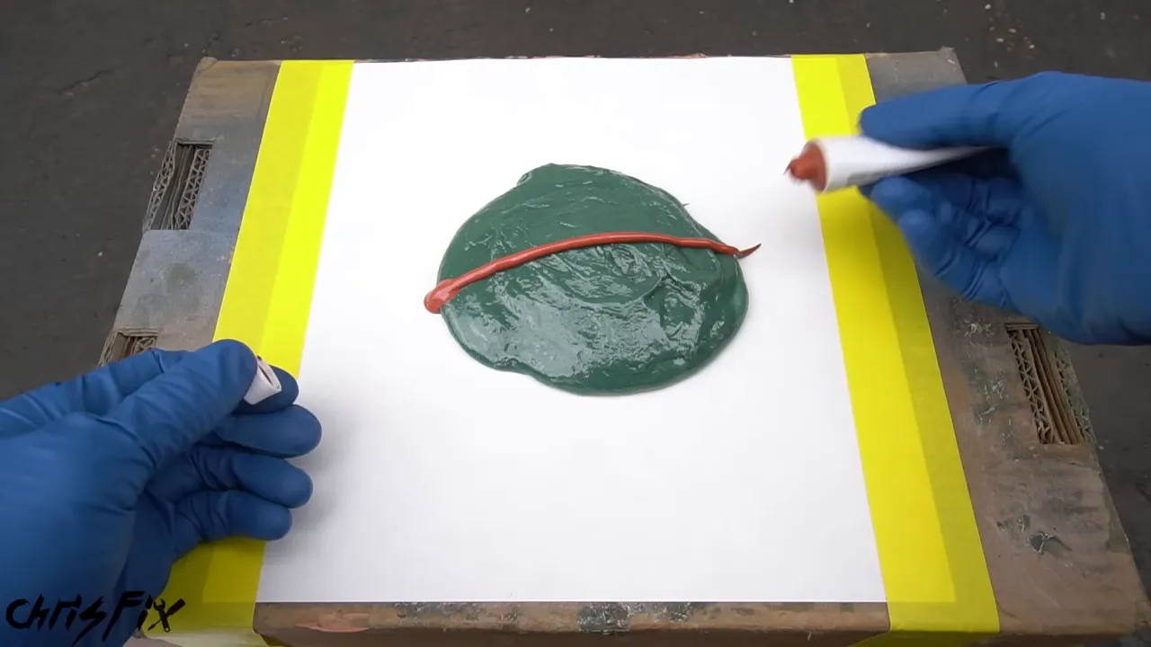 A circular mound of green fiberglass filler with a red bead of hardener across it