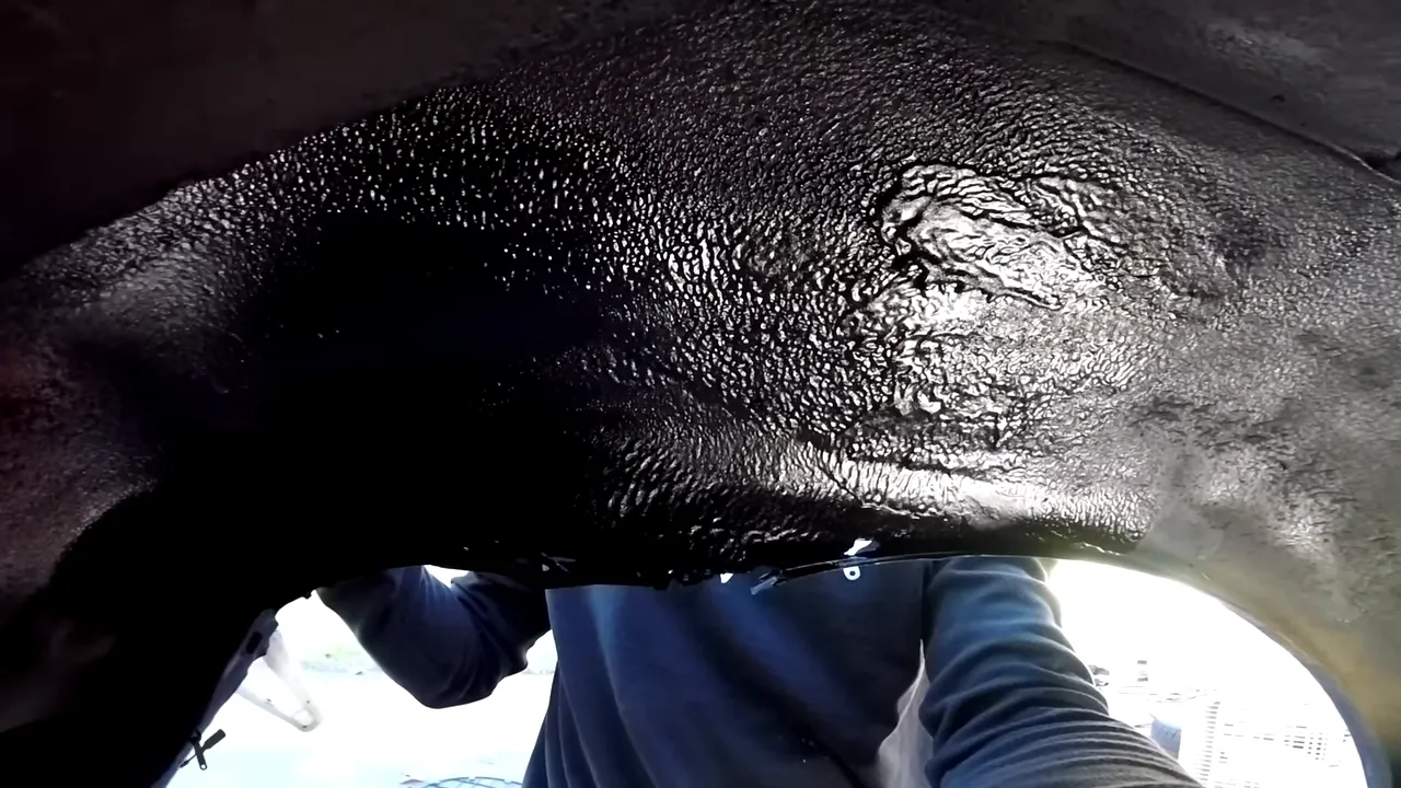 Black textured coating covering the inside of the rear wheel arch