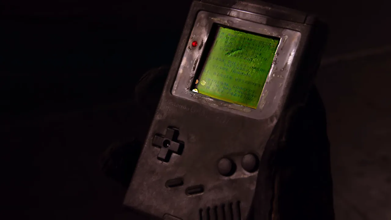 Charred Game Boy with its green display powered on