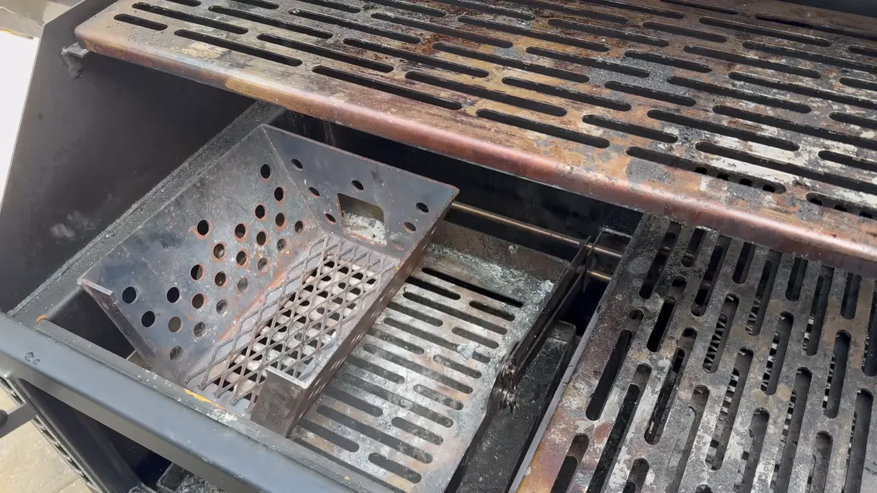 Fire-management basket positioned inside the left side of the open grill