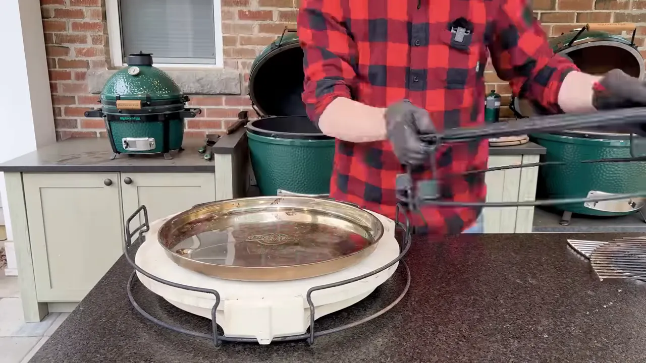 Layered ceramic heat deflectors, a drip pan, and cooking grates assembled on a rack