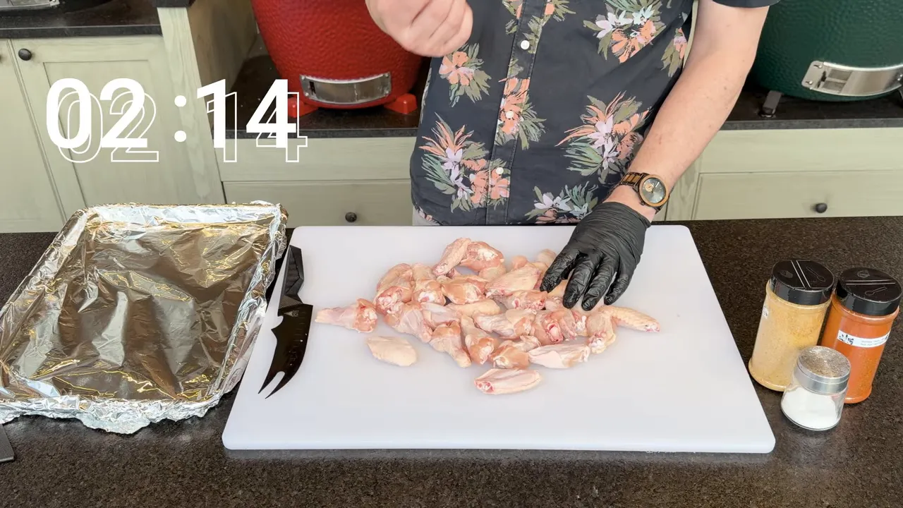 Split raw chicken wings on a white cutting board with an elapsed timer reading 02:14