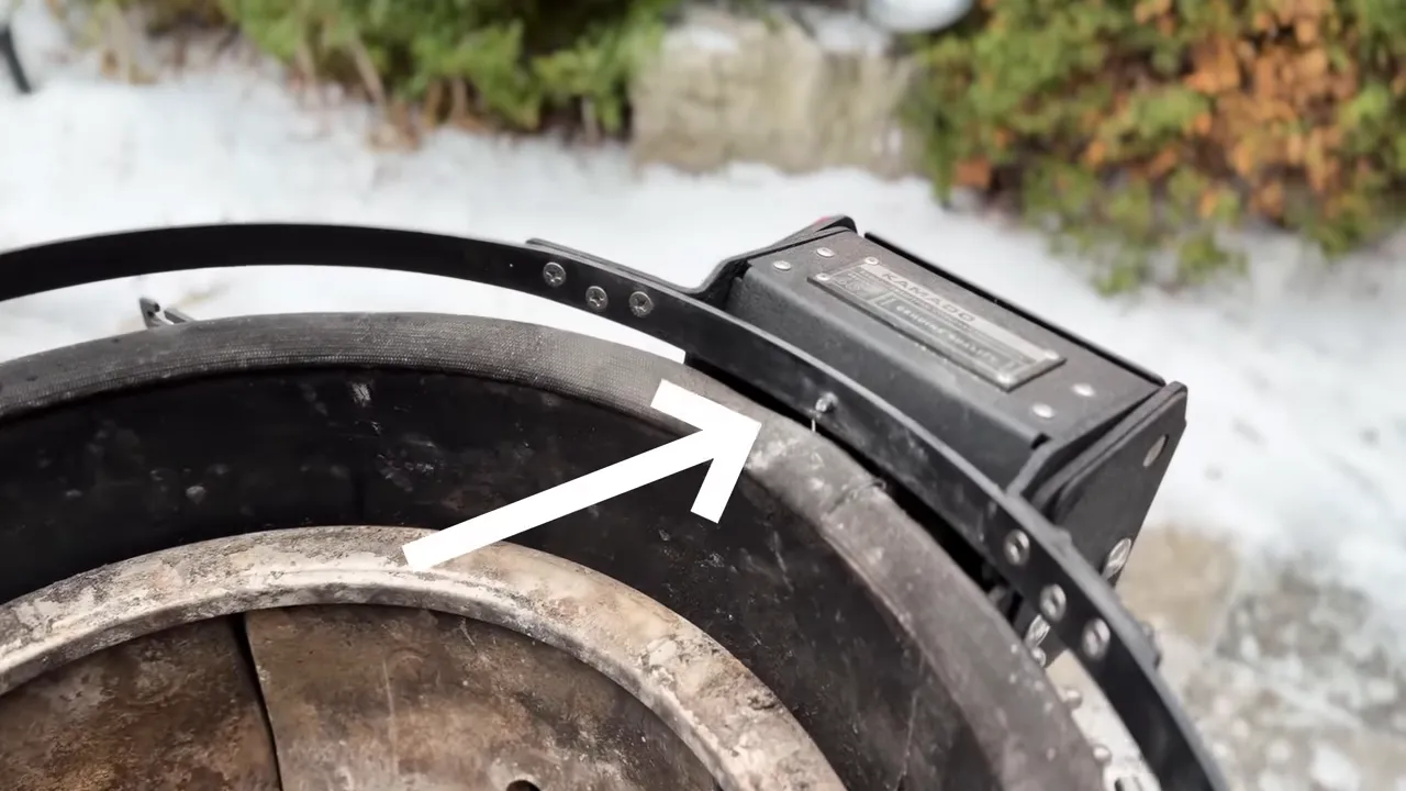 Arrow pointing to a locating tab near the rear hinge and upper grill band