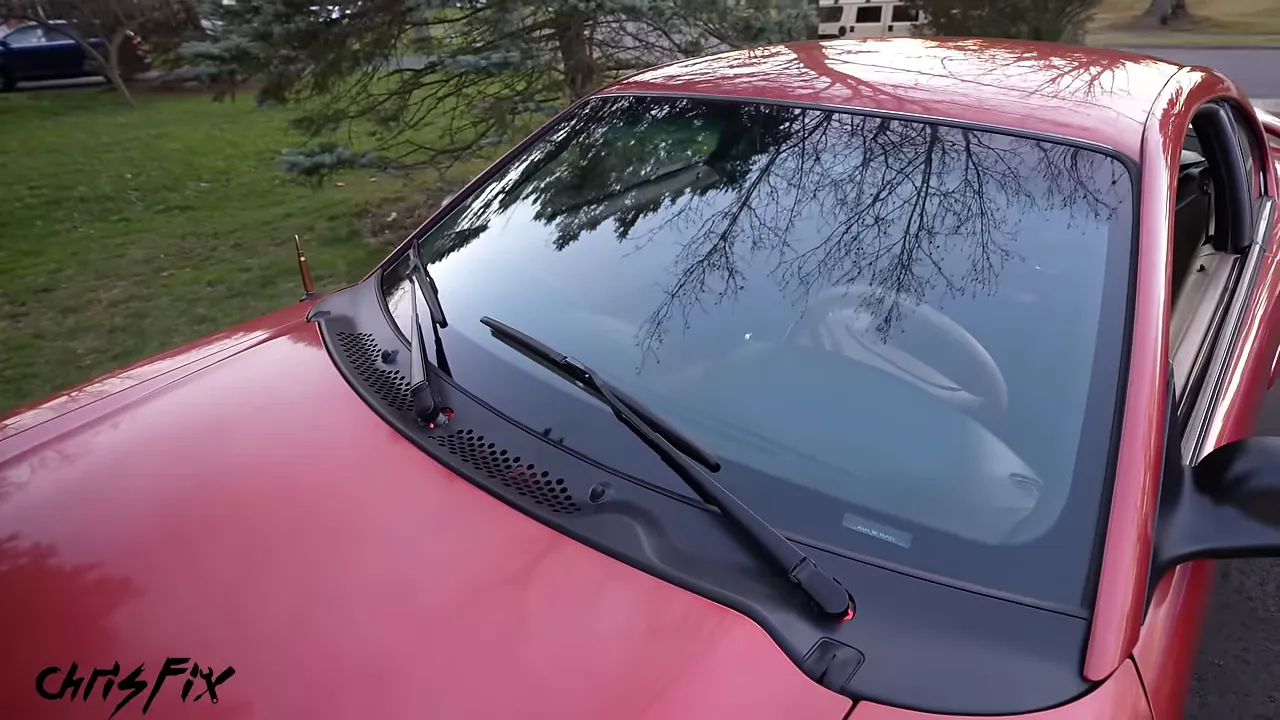 Red Mustang windshield with both wipers positioned low above the black cowl
