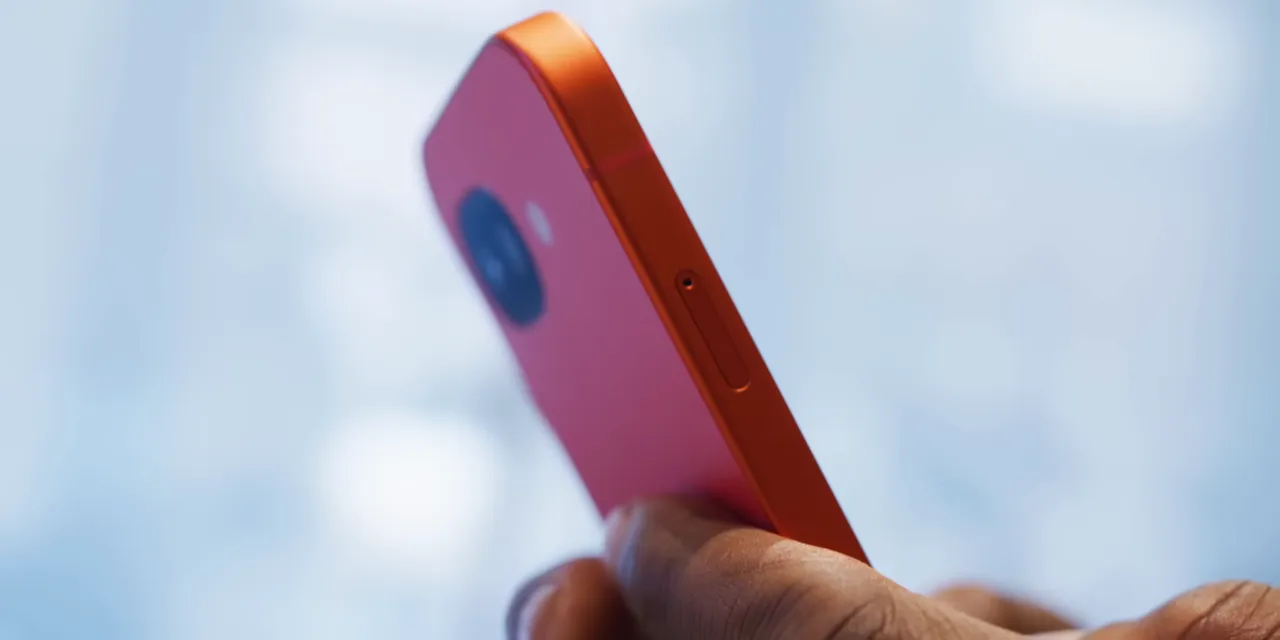 Close side-angle view of a red Pixel phone with its rear camera area and flat edge visible