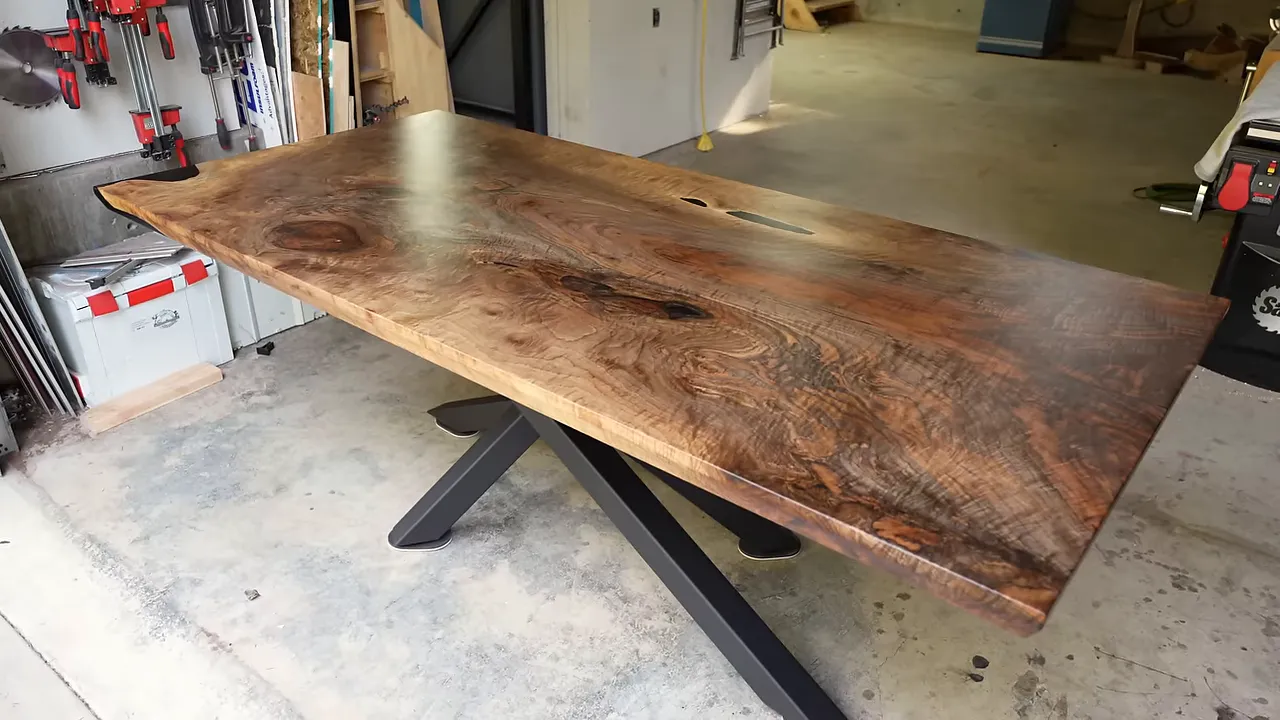 Finished figured walnut dining table with a black spider-style steel base