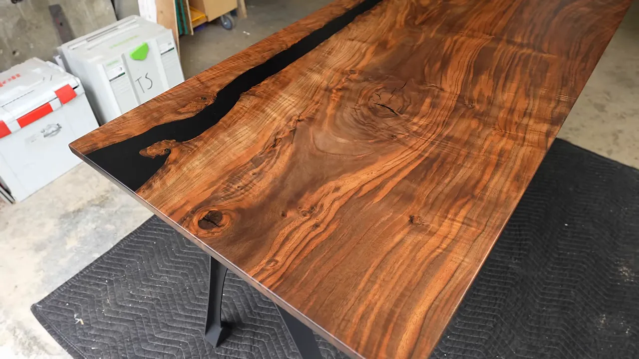 Finished walnut desk with flowing grain and a black epoxy section