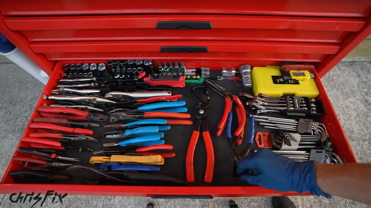 Open red toolbox drawer with pliers arranged in organized rows