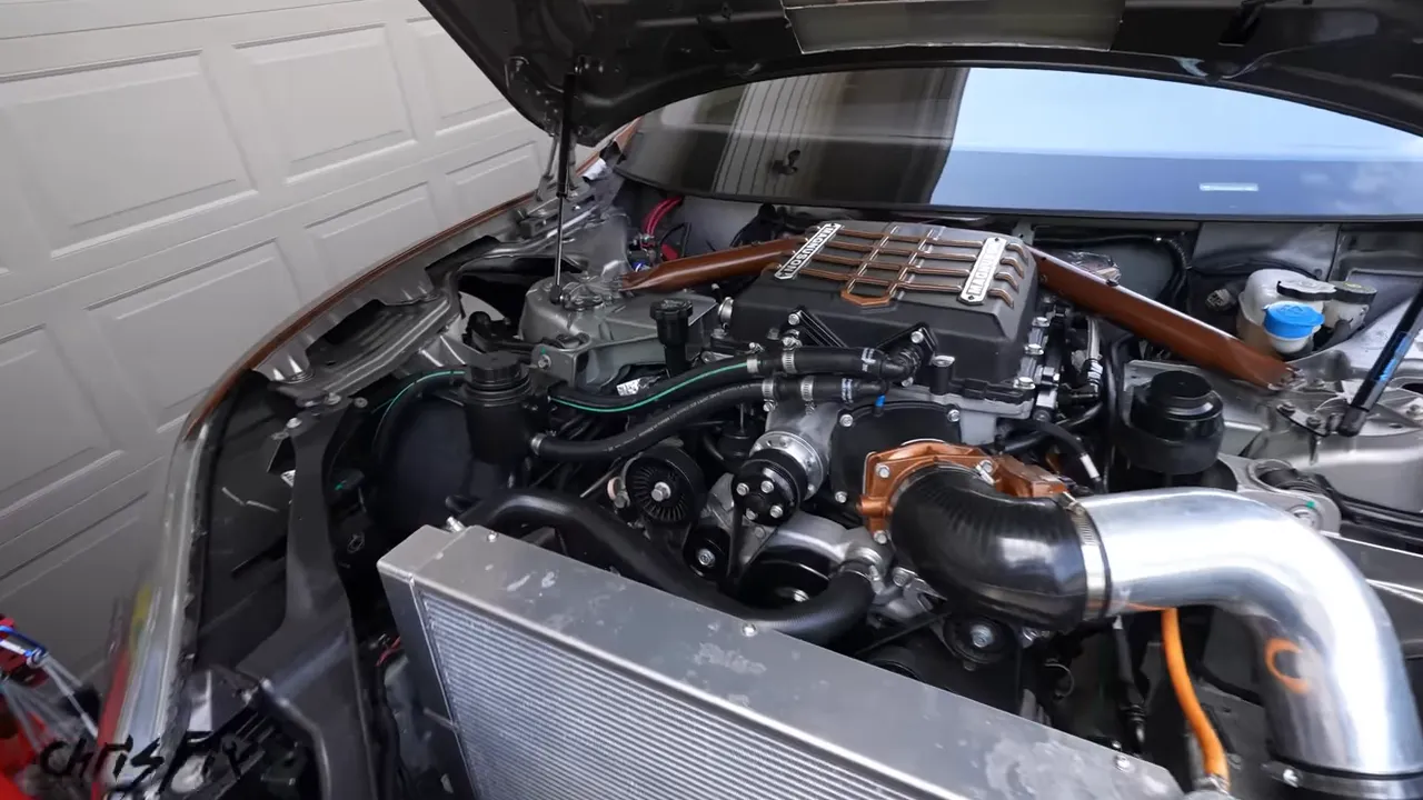 Combustion engine, belt-driven accessories, and intake piping under the Model S hood