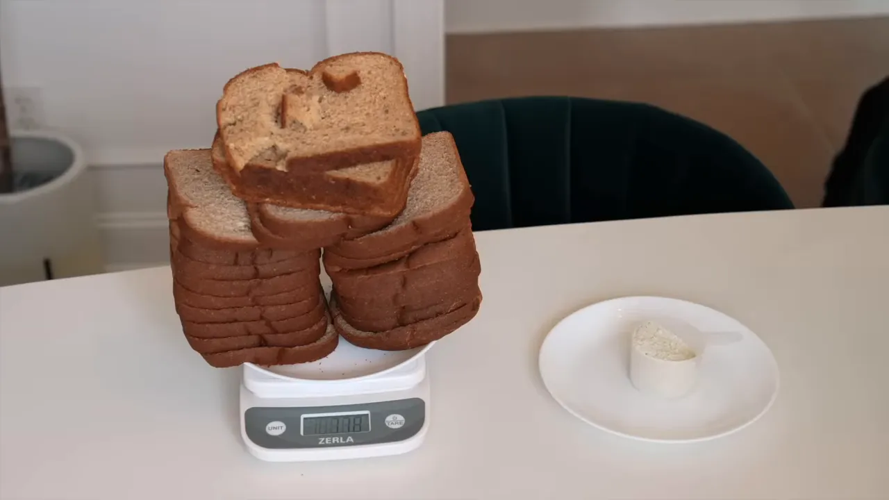 A large stack of bread on a kitchen scale beside a plate holding a scoop of powder
