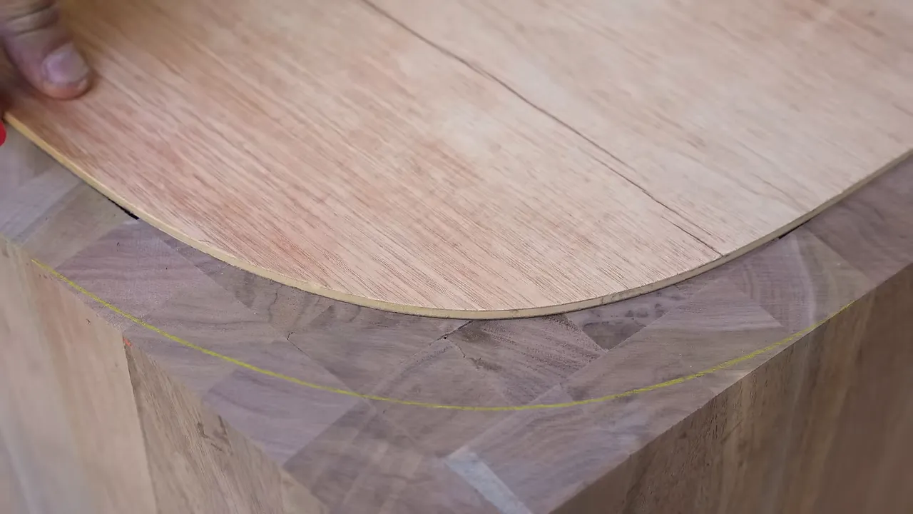Plywood curve template resting on walnut blocks beside a marked inner curve