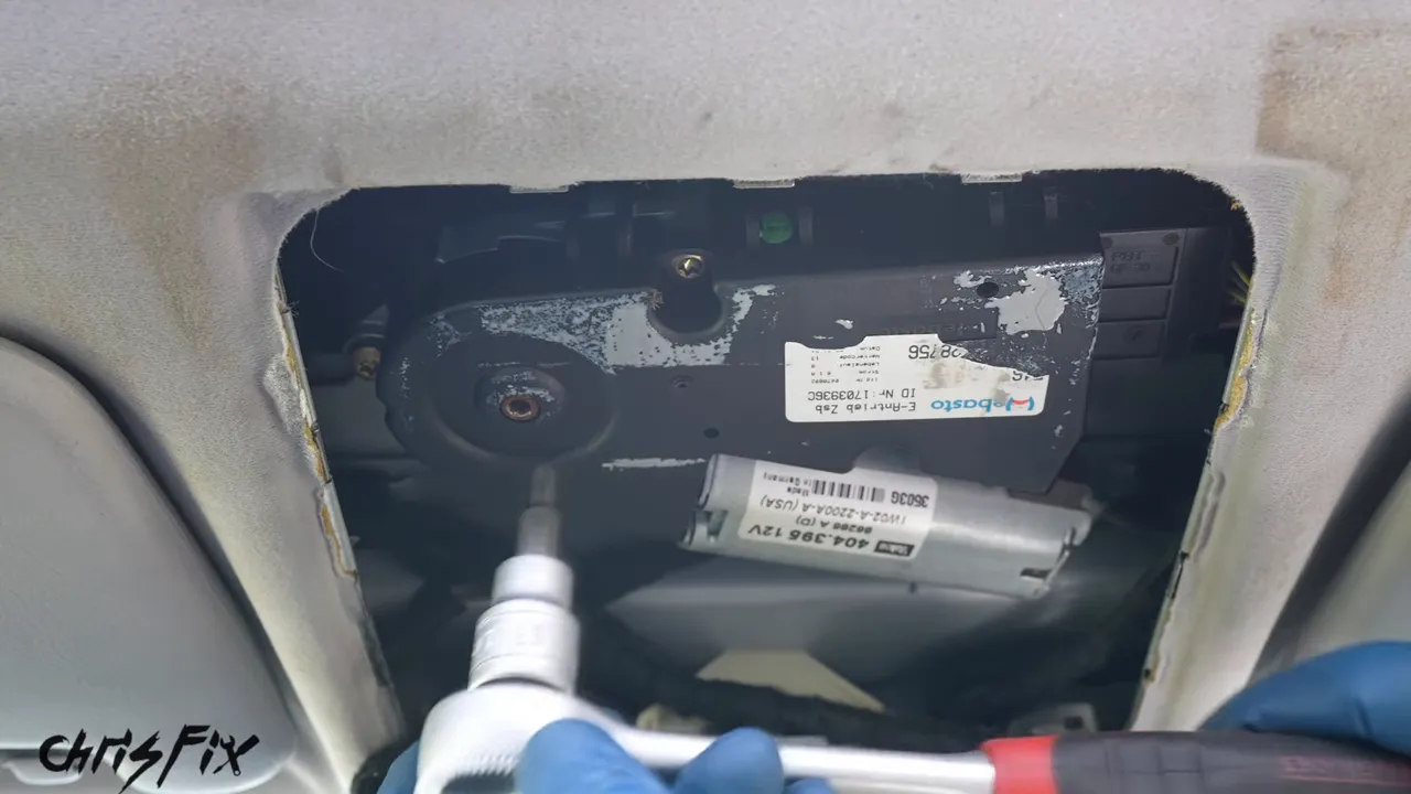 Ratchet and Torx bit engaged with the exposed sunroof motor above the windshield