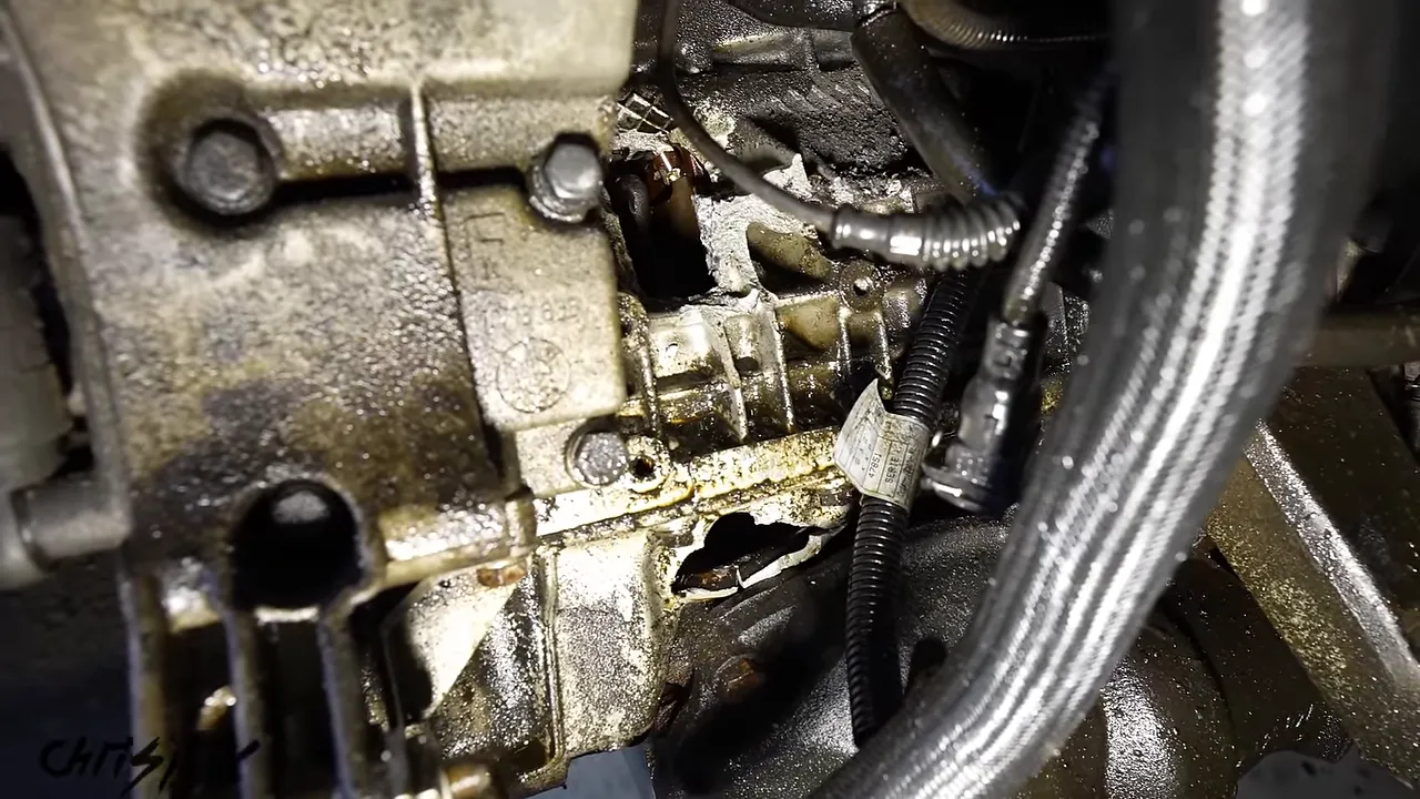 Broken openings in the side of the BMW engine block beside hoses
