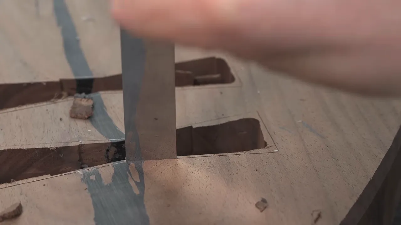 Chisel trimming the wall of a bowtie-shaped recess across a filled crack