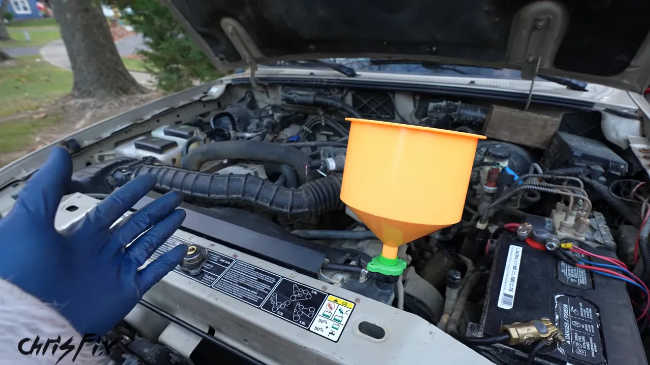 Orange spill-proof funnel mounted above the radiator in an open engine bay
