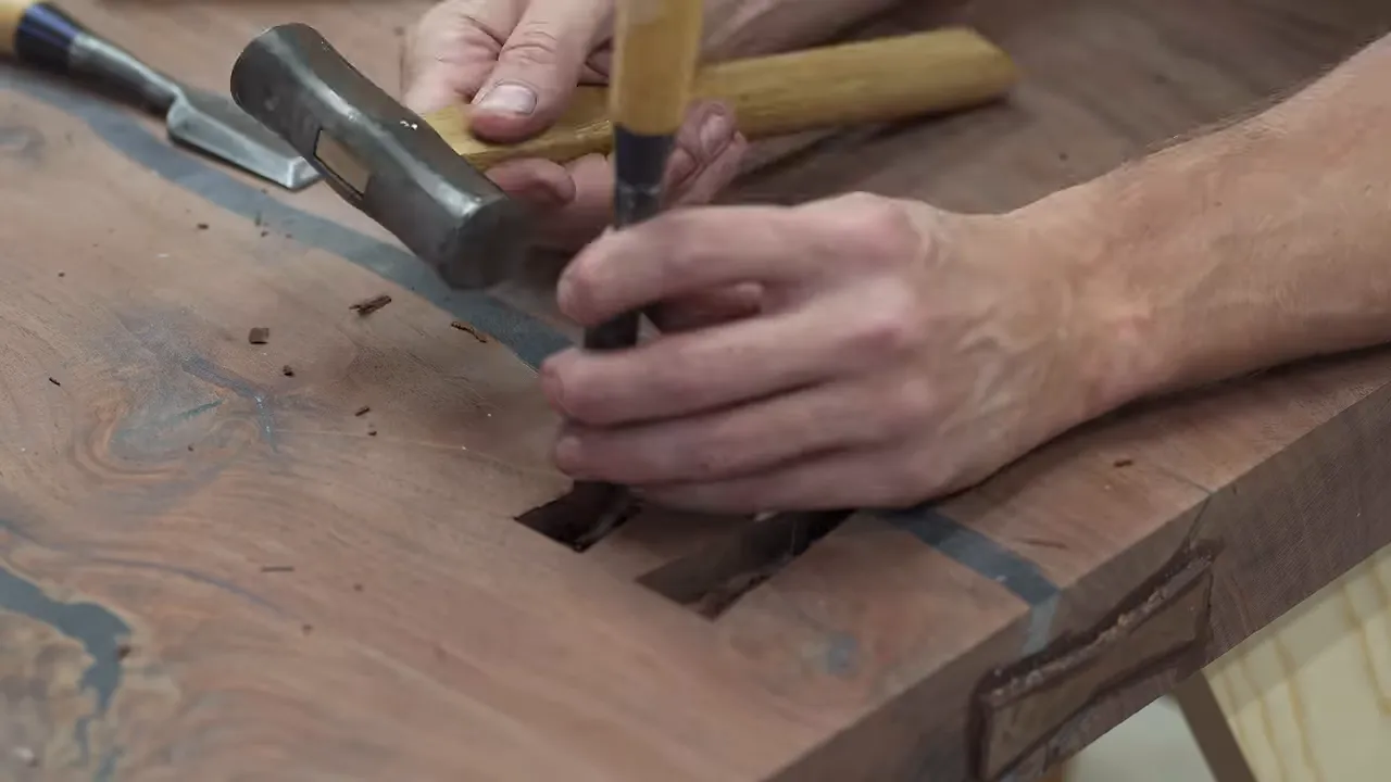 Two bow tie recesses crossing an epoxy-filled crack in the walnut slab