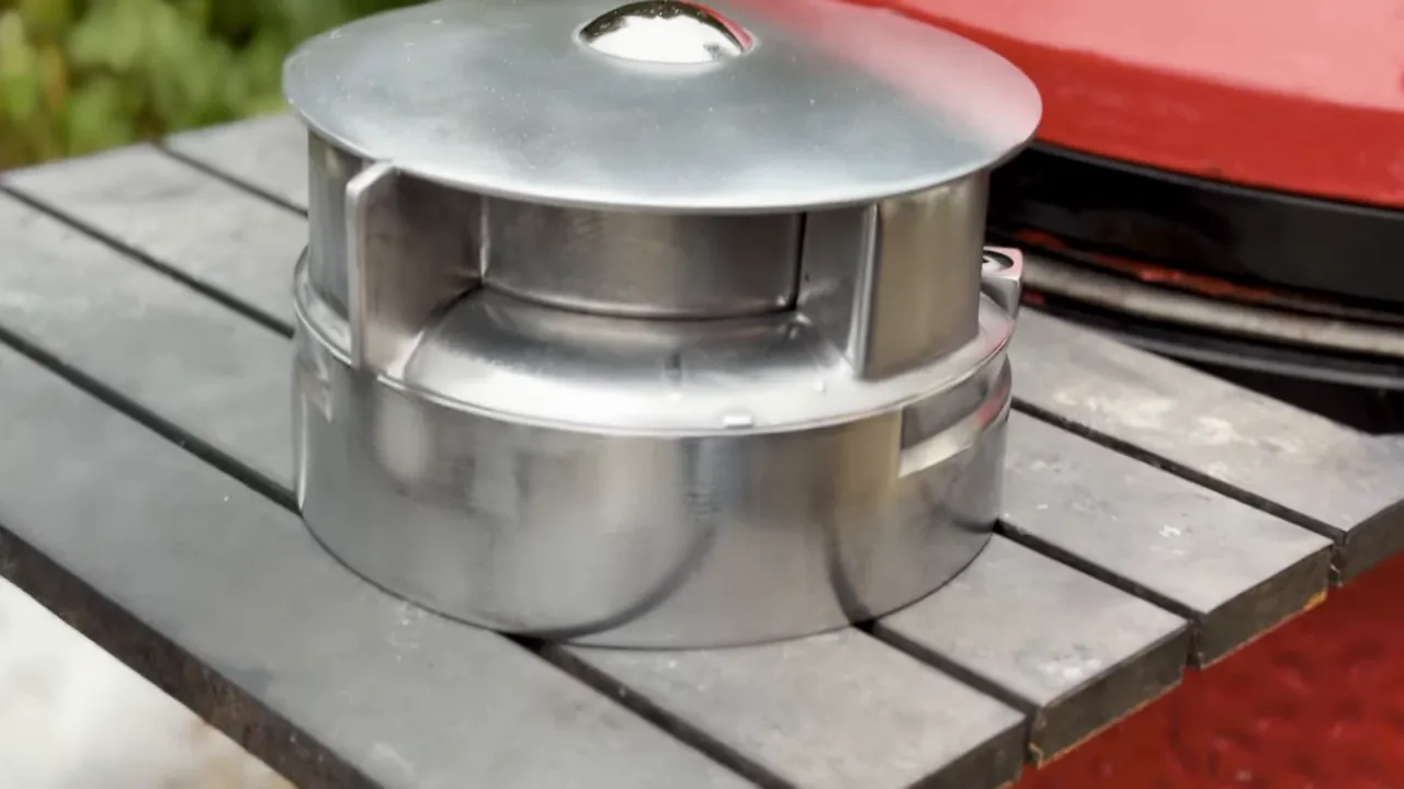 Polished silver-colored Kontrol Tower resting on the Kamado Joe side shelf