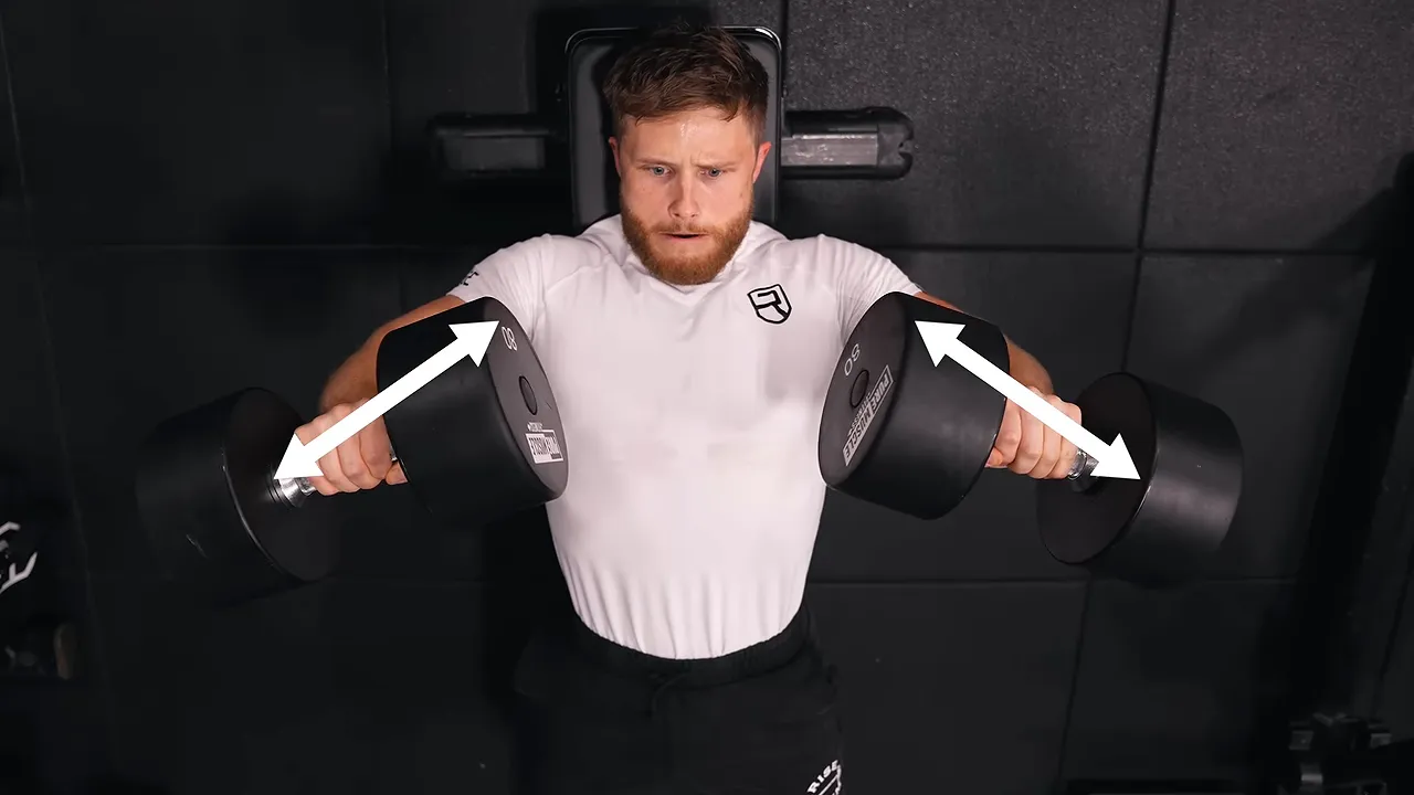 Overhead dumbbell press demonstration with arrows showing the elbows angled away from the torso
