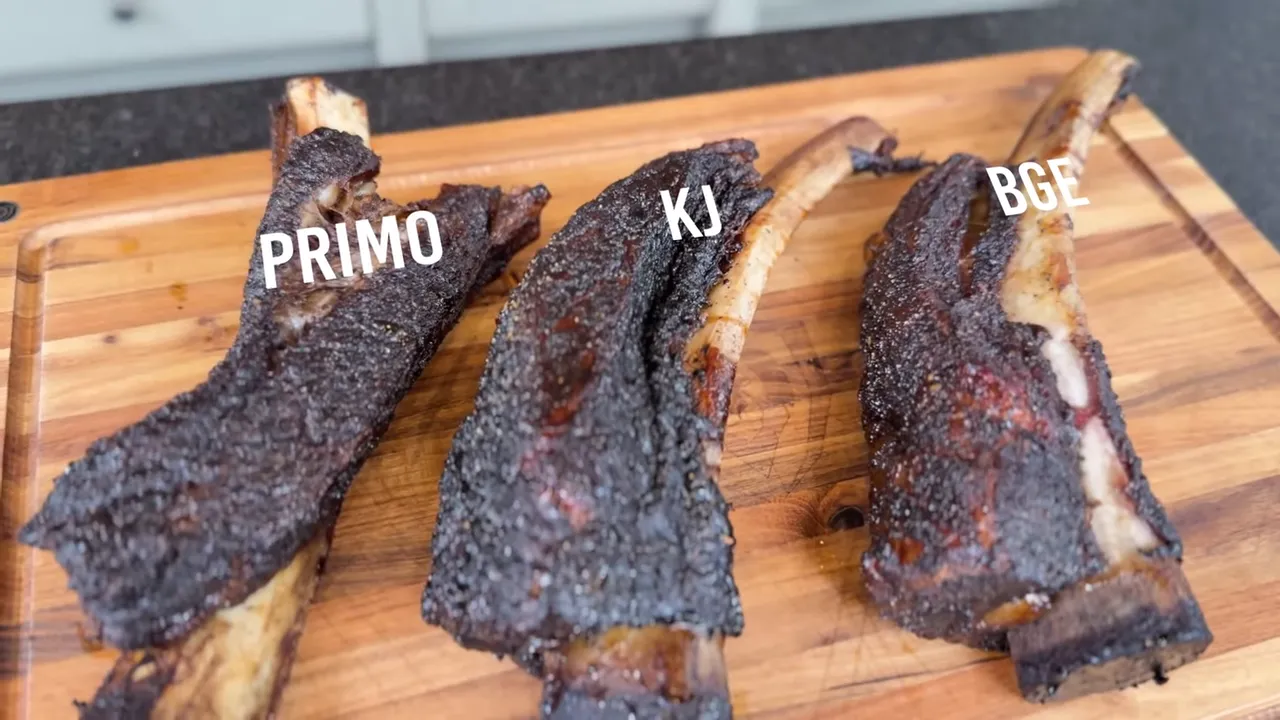 Three cooked beef ribs on a wooden board labeled Primo, KJ, and BGE