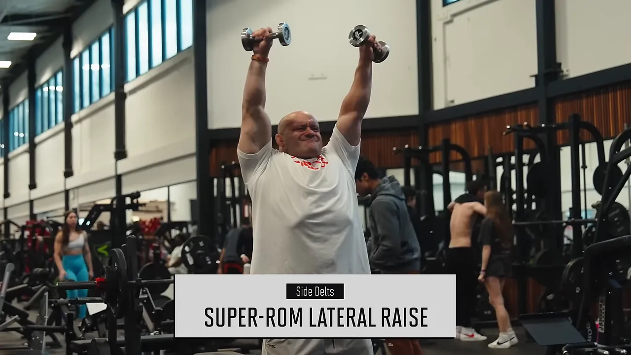 Mike holding dumbbells above shoulder height during a super-ROM lateral raise